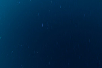 Moving stars at night, dark blue universe background. Long exposure shot. 