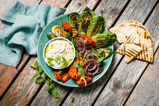 Grilled vegetables served with pita and baba ganoush on plate
