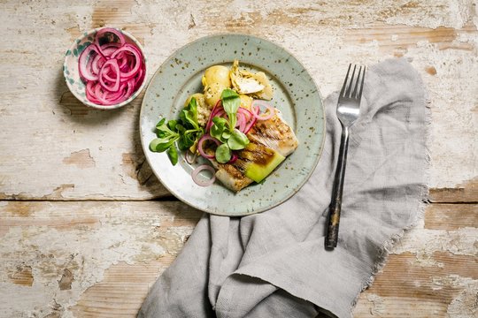 Zaatar baked cod in purjo with potato and pickled onions