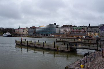 Pier and promenade in the city of Helsinki in Finland on a warm day of snowless December with unfrozen water.