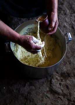 High angle view of man's hands preparing capellini