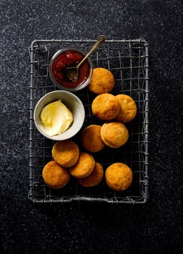 Overhead view of biscuits with butter and jam on cooling rack