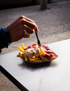 Close up of man's hand having French fries outdoors