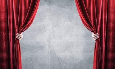 Concrete wall behind drapery curtain and hand opening it