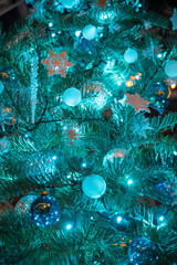 Obraz na płótnie Canvas Abstract medium close up of a Christmas tree with lights, ornaments, stars, balls, icicles, and other decorations that all have blue tones. 