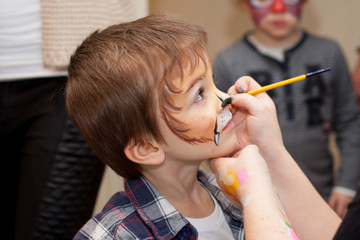 Little boy with painted face as lion