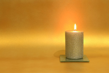 Płonąca świeca na złotym tle, dekoracja, religia i kultura.