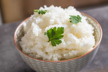 Cooked rice in bowl on kitchen table - close up
