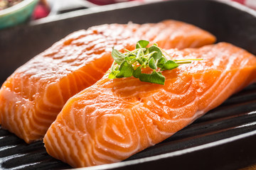 Fresh raw salmon fillets served in cast iron grill pan