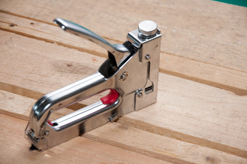 Furniture stapler closeup on wooden background. Furniture maker tool