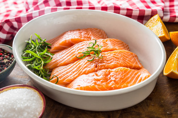 Raw salmon fillets with herbs in a baking dish