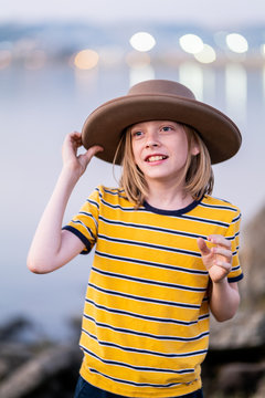 Tween smiling while adjusting brim of hat