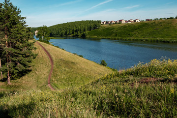Fototapeta na wymiar landscape hilly terrain river flows on one side a field