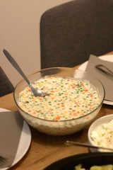 Bowl of Olivier salad, served on a table. Selective focus.