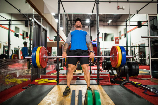 bodybuilder completes deadlift in the gym.
