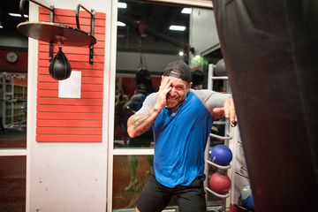 kickboxer protects his face while traing on punching bag