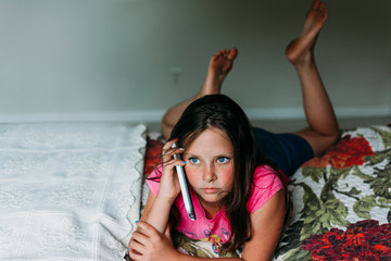 Tween Girl Laying on a Bed Talking on a Cell Phone