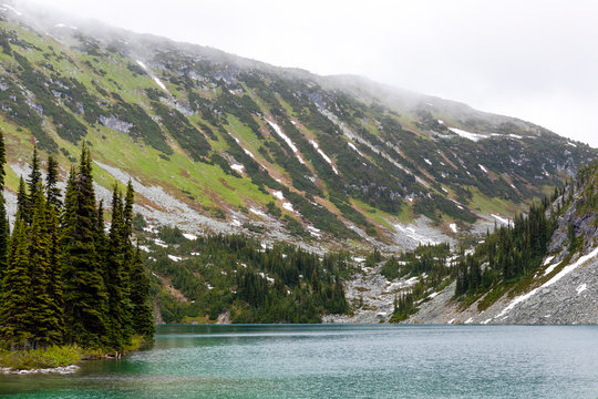 A beautiful alpine lake on a cloudy, rainy summer day in the Coast Mountains around Pemberton, British Columbia.
