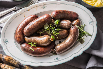 Roasted sausages in pan with rosemary. Traditional european food bratwurst jaternice or jitrnice