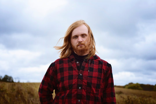Young Man With Long Red Hair and Beard Outside in the Country
