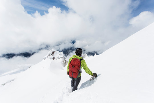 A young man descends from the summit of Mt. Hood on a cloudy day.