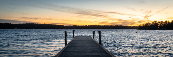 Old wooden jetty or pier background on the seaside. Sea bay at sunset. Horizon line, skyline with...