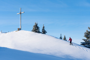 nice senior woman snowshoeing on the Nagelfluh chain above a sea of fog over Bregenz Wald...