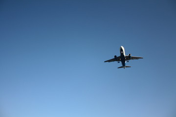 Fototapeta na wymiar Flying airplane against the blue sky