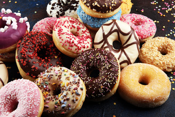 assorted donuts with chocolate frosted, pink glazed and sprinkles donuts