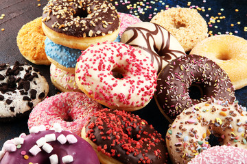 assorted donuts with chocolate frosted, pink glazed and sprinkles donuts