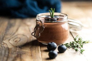 Chocolate mousse in glass jar with berries on a rustic background copy space. Homemade dessert.