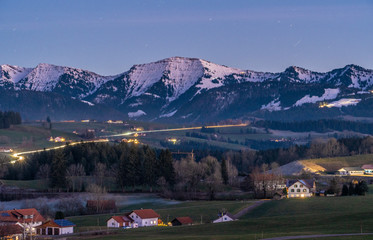Fototapeta premium Hochgrat summit in the Nagelfluh chain with village of Oberreute in the foreground at Dawn, Allgau Alps near Oberstaufen, Bavaria, Germany, landscape photography