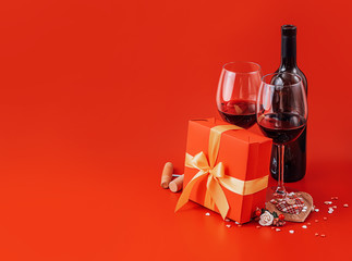two glasses of wine and a gift in a luxurious box
