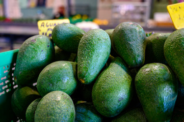 Fresh ripe green avocados in box on farmers market in Spain