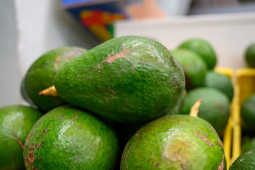 Fresh ripe green avocados in box on farmers market in Spain