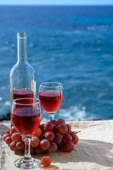 Two glasses of rose wine served outdoor with pink grapes fruits on tropical island La Palma, Canary islands, Spain with beautiful blue ocean view
