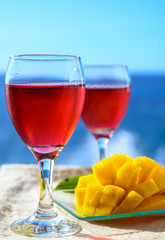 Two glasses with rose wine served outdoor with exotic fruits on tropical island La Palma, Canary islands, Spain with beautiful blue ocean view