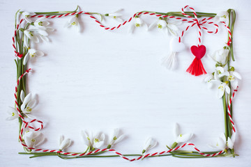 White wooden background with spring snowdrops and red and white hearts.