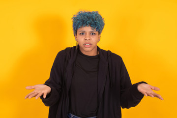 young african american girl or woman with blue hair isolated on yellow background