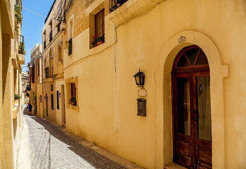 Fototapeta na wymiar An empty narrow street with traditional Maltese architecture