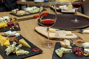 A cheese cutting from different types of cheese on a wooden board