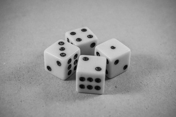 Four white dice on a gray background