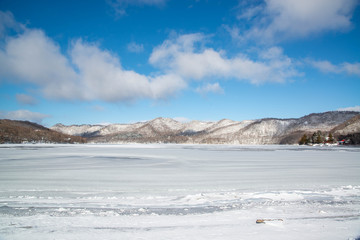 Fototapeta na wymiar 凍った湖畔と山々　赤城山　凍結した大沼湖