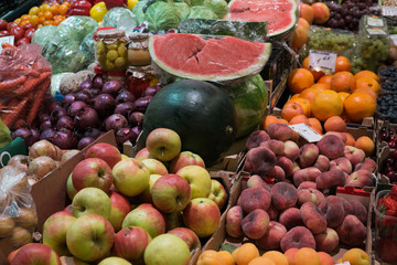 A counter with different, fresh fruits and vegetables at the city market.