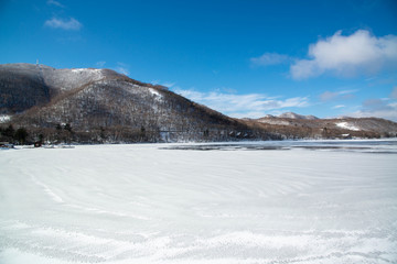 Fototapeta na wymiar 凍った湖畔と山々　赤城山　凍結した大沼湖