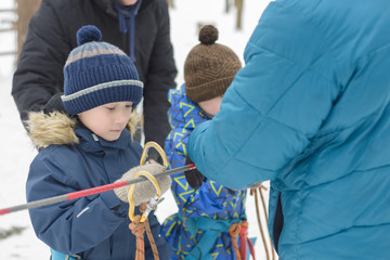 Children are instructed in an extreme park. Training in working with carbines and insurance. Children play in a rope park in winter.