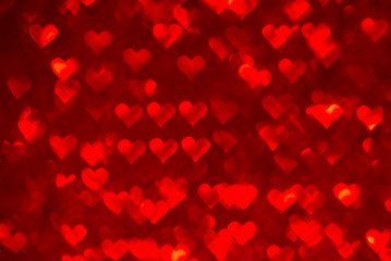 Fototapeta na wymiar Abstract light, red bokeh pattern in heart shape. St Valentides Day or Holiday concept, background image.