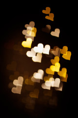 Abstract light, golden bokeh pattern in heart shape. St Valentides Day or Holiday concept, background image.