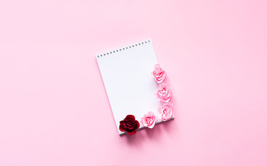 Festive concept with notebook and rosebuds on pink background. Valentines Day. Template mock up of greeting card or text design. Close-up