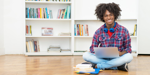 African american male student with computer and copy space